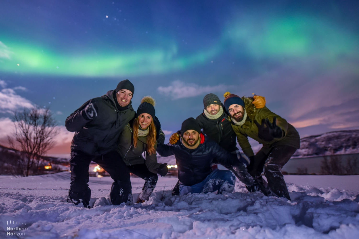 A group of people with Northern Lights in the background