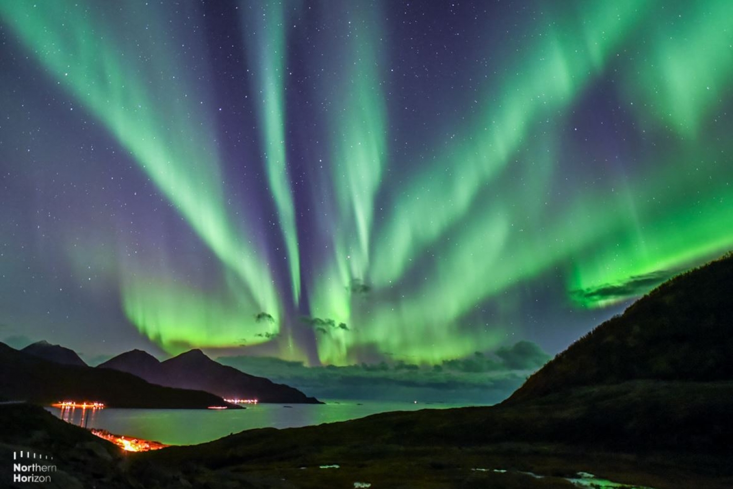 Northern Lights above sea and mountains