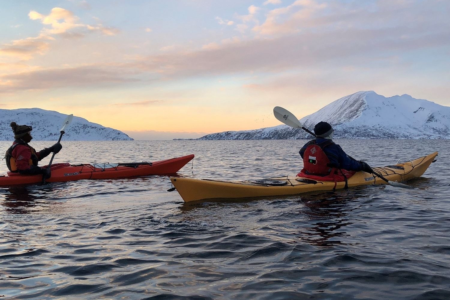 Two people kayaking in winter landscape