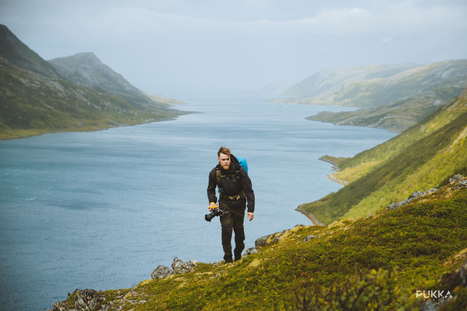Man hiking on the mountain, fjord in the background