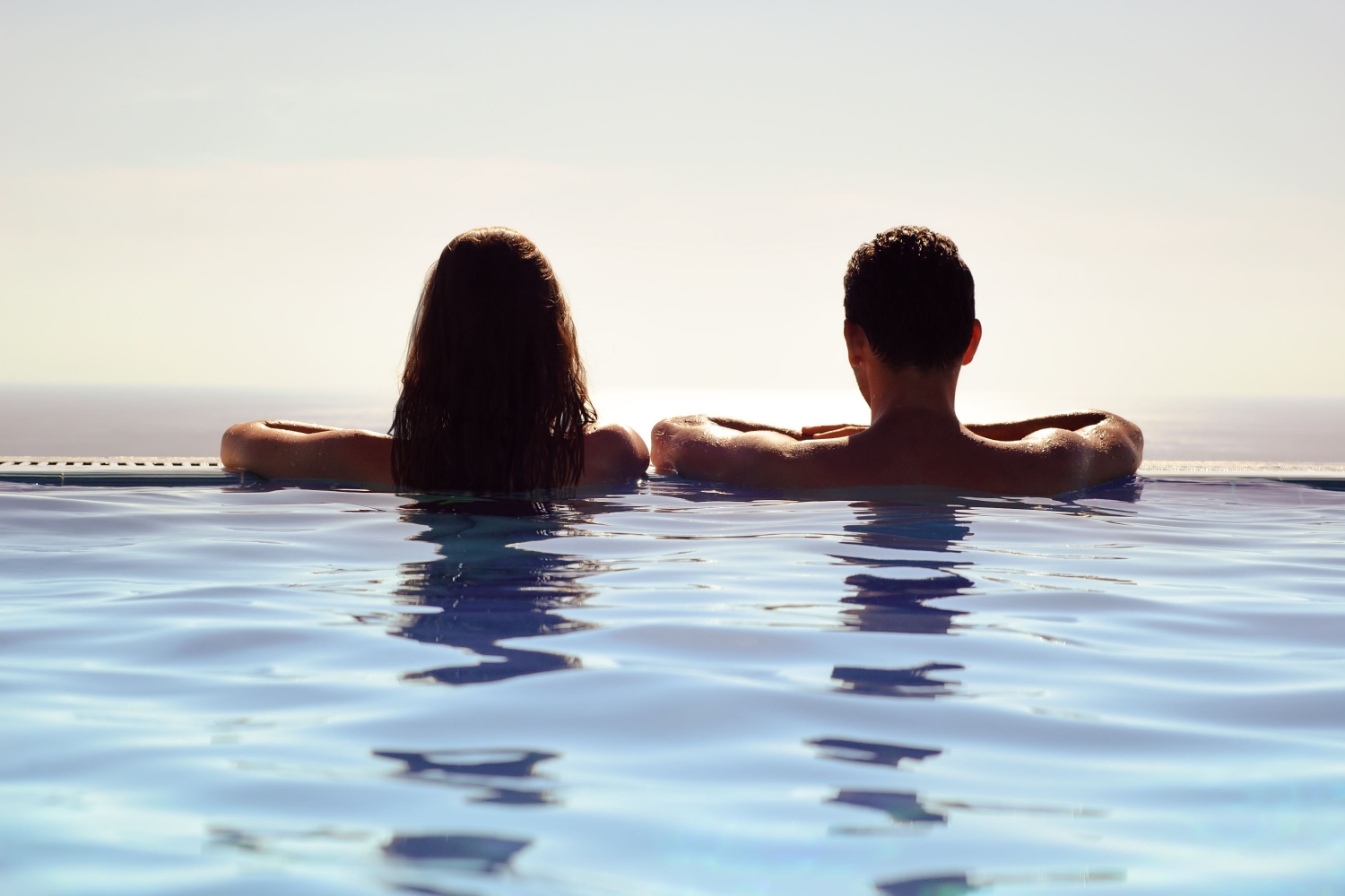 Man and woman in a pool looking out on the scenery