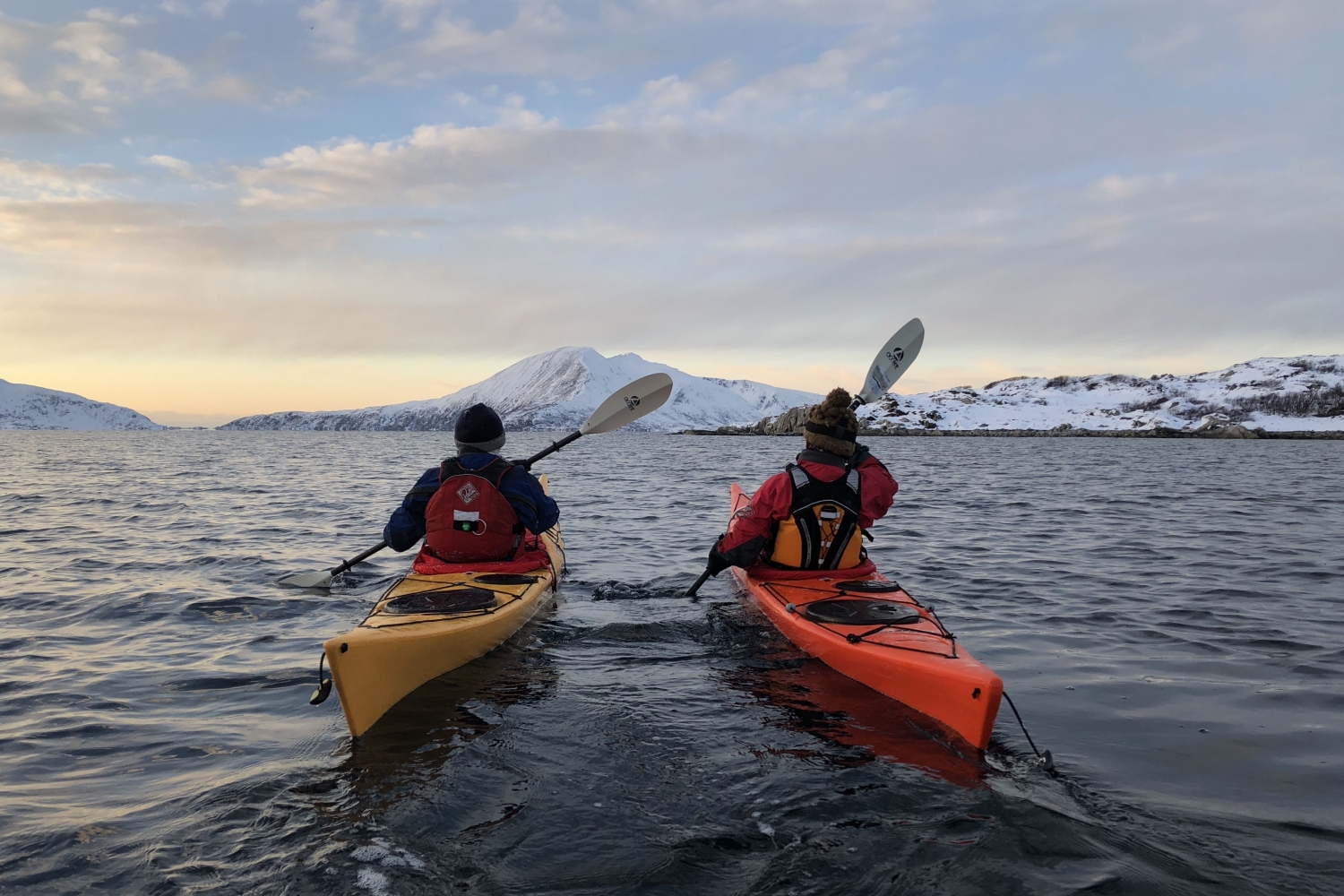 Two people kayaking in winter landscape