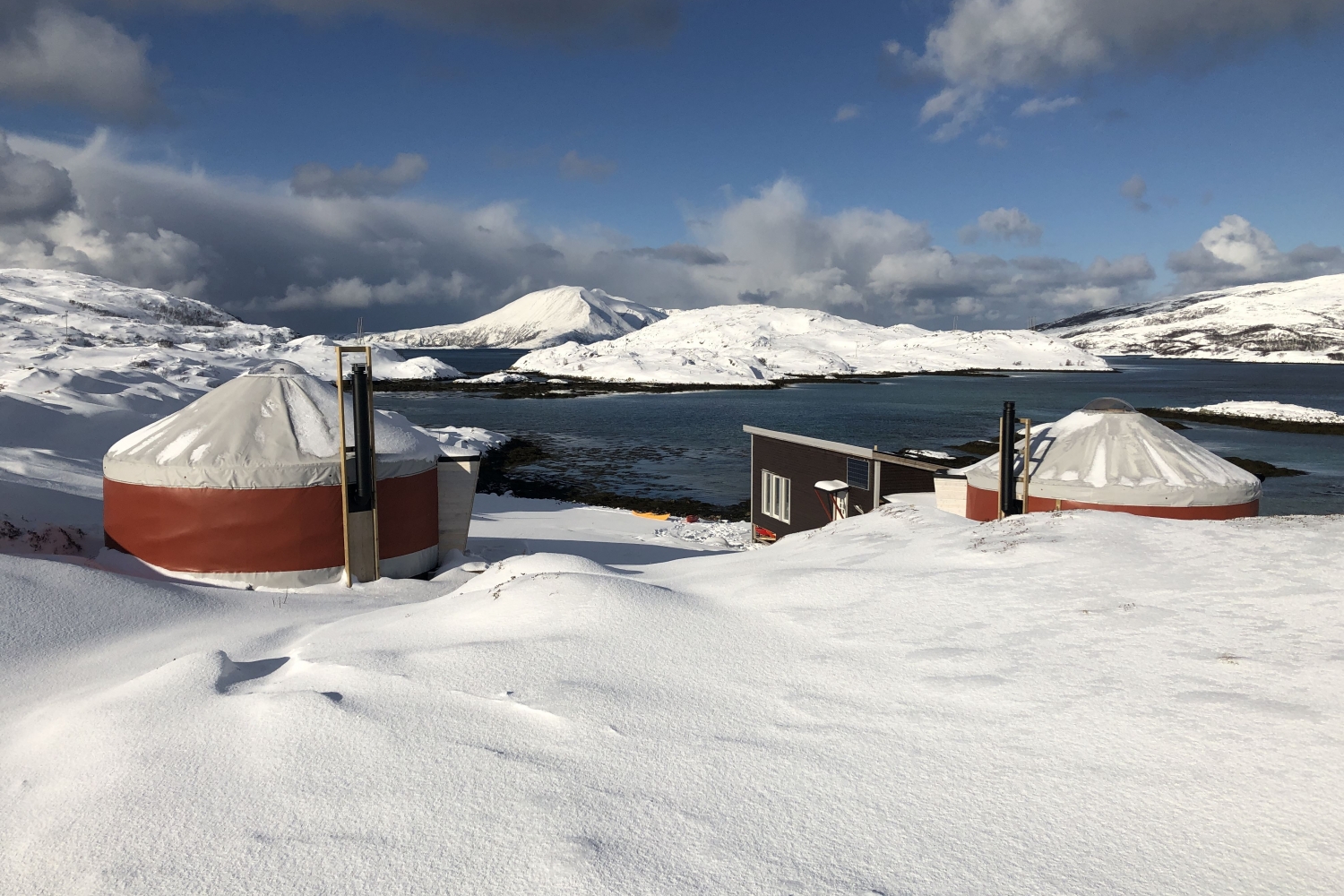 To yurter i vinterlandskap ved havet