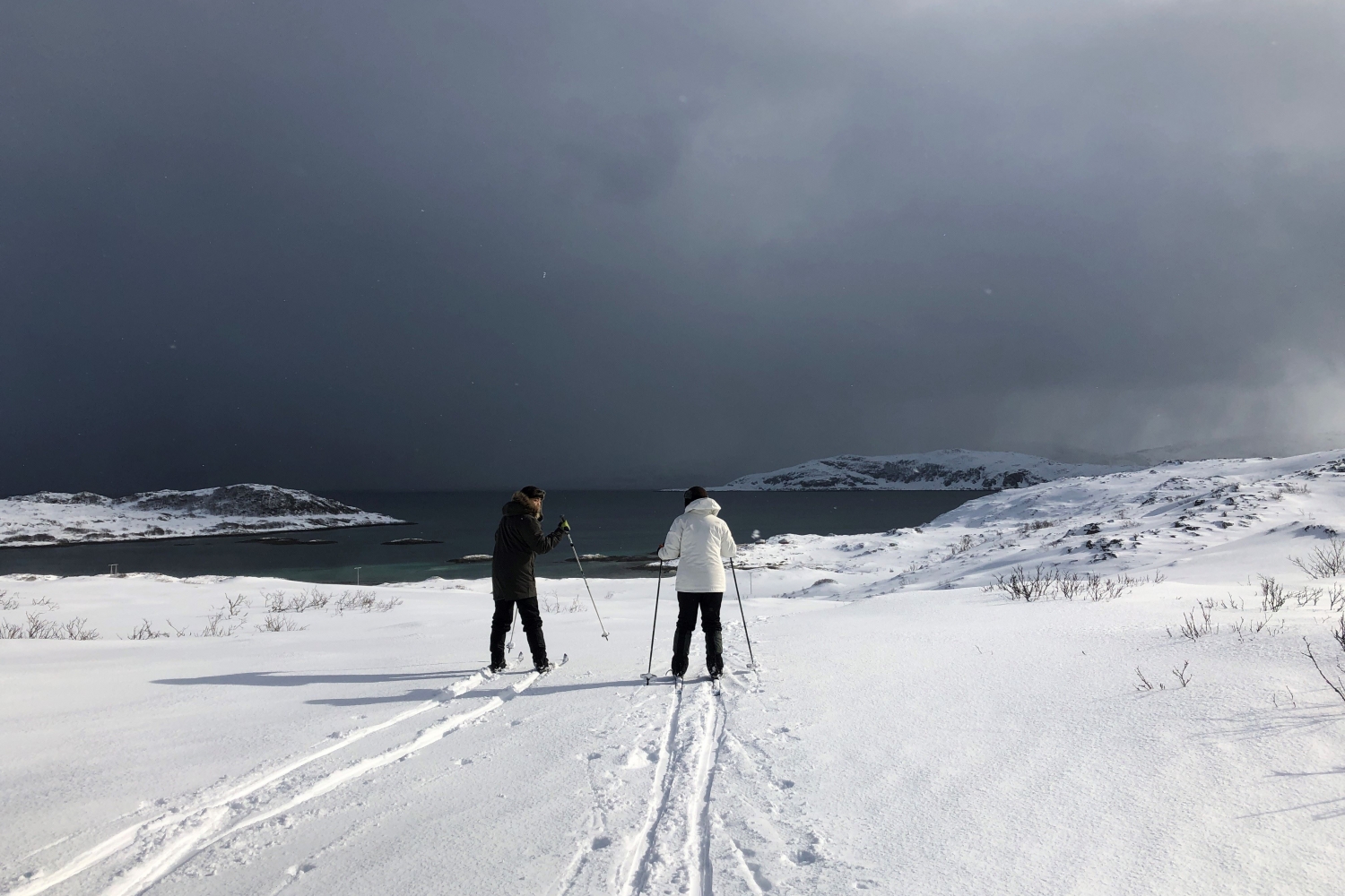 Mann og kvinne går på ski i vinterlandskap