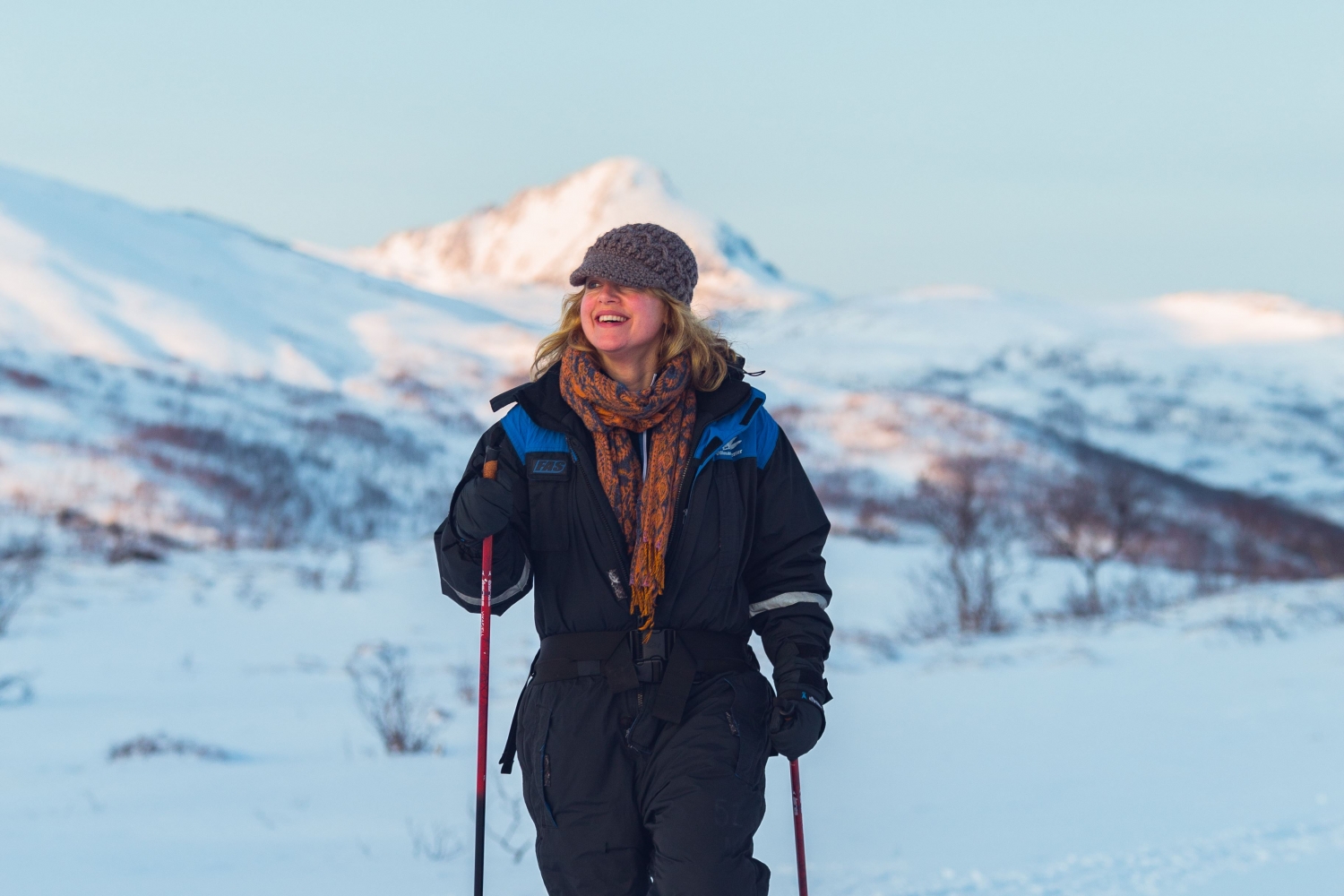A woman snowshowing in a snowy Arctic landscape