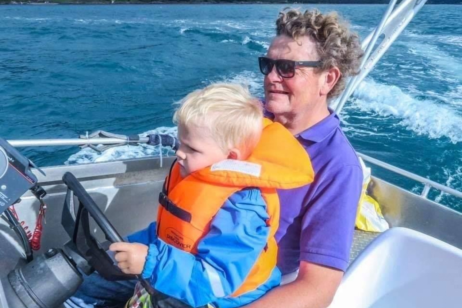 Mann og barn kjører båt