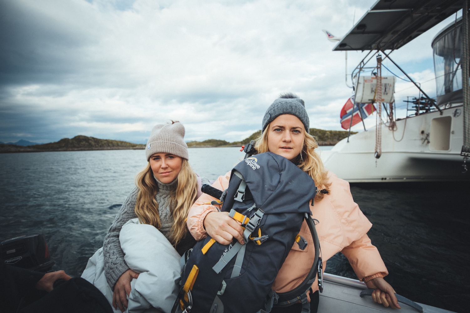 two women on dinghy holding life jackets