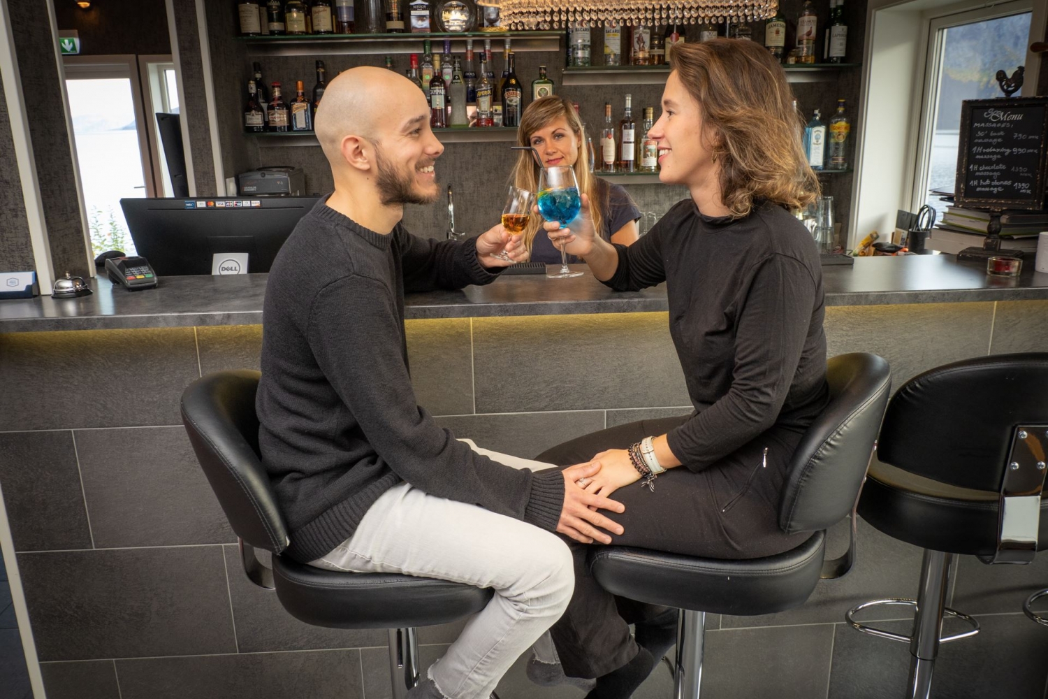 et parr som nyter en drink i baren