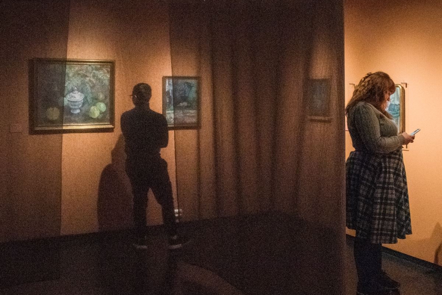 two people inside the museum looking at paintings