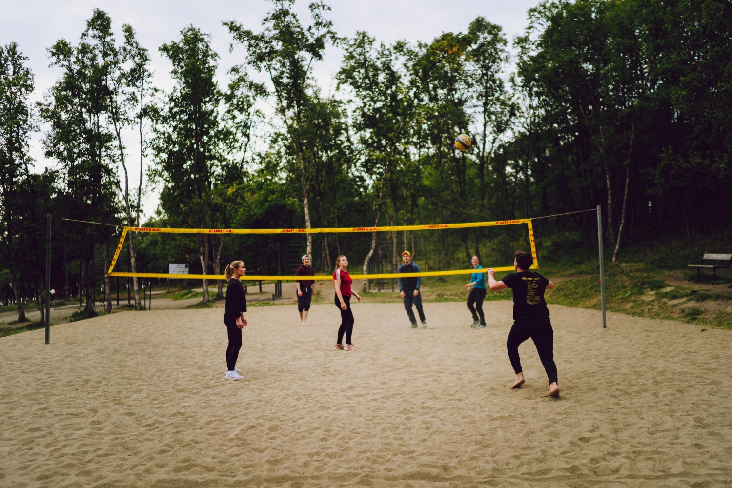 a group of friends playing sand volleyball 