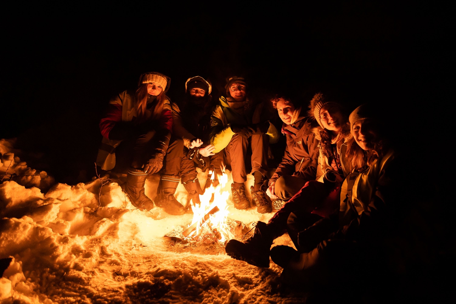 people sitting around bonfire