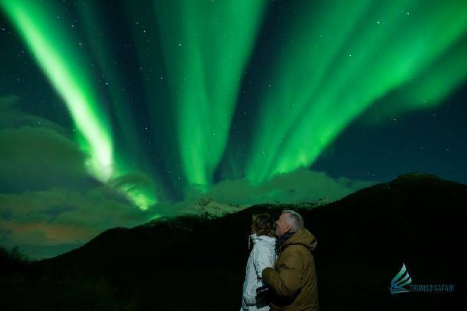 two people admiring the northern lights in the sky