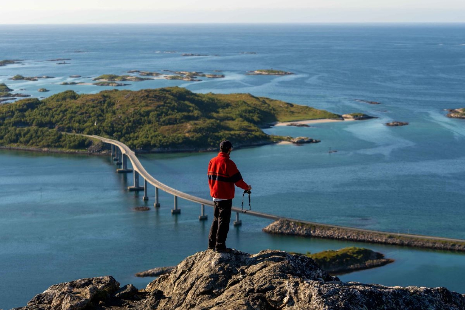 Person som tar bilde av Sommarøy og brua over til øya