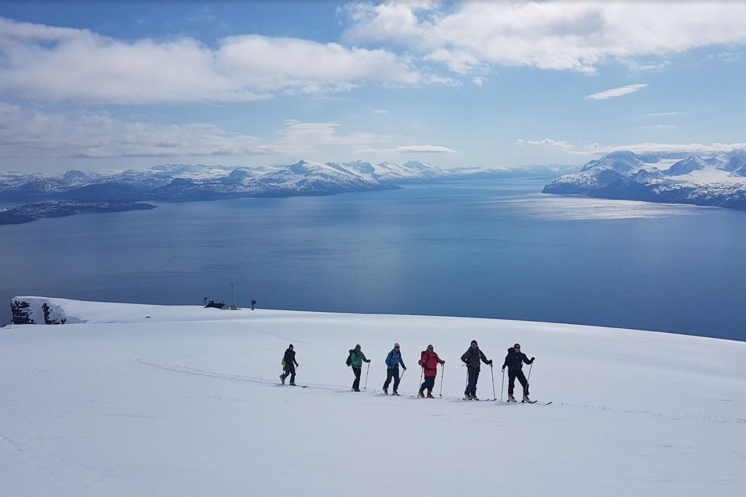 seks prsoner på skitur med fjorden bak