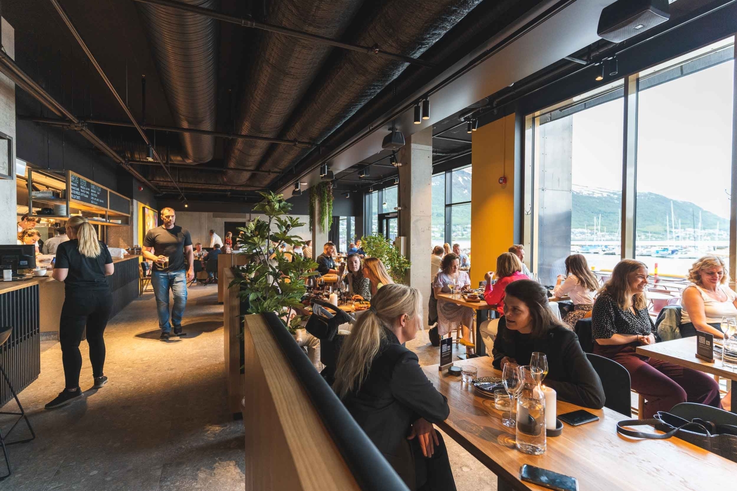 Folk spiser på Delikatessen Tromsø med utsikt.