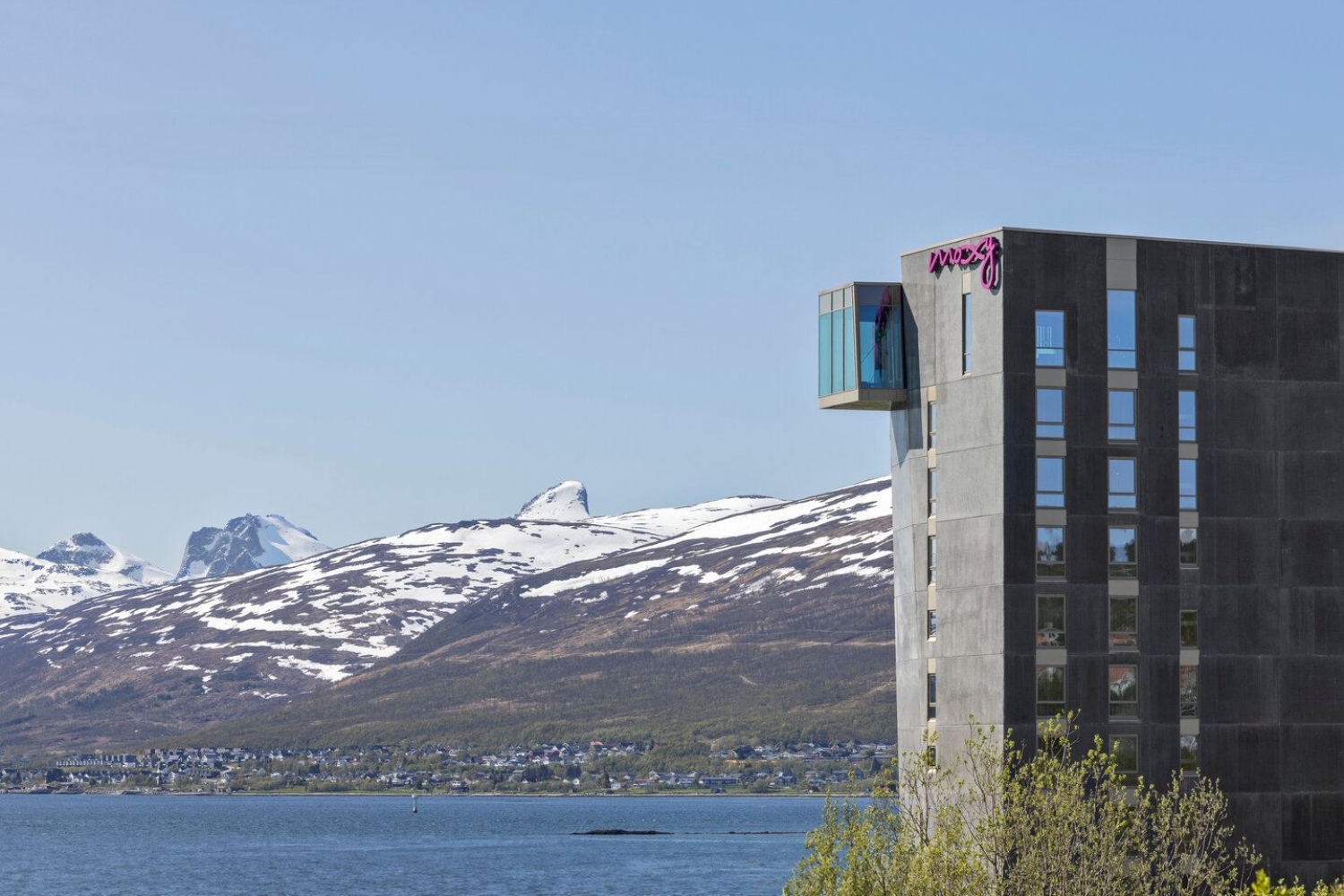 Moxy hotell Tromsø sett fra litt avstand, med Kvaløya i bakgrunnen.