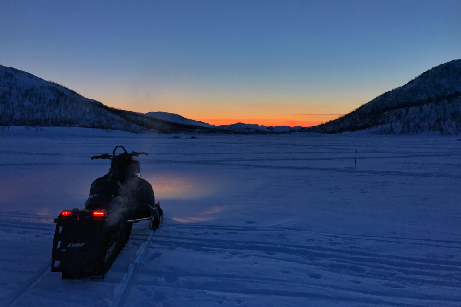 Snøscooter og arktisk lys nord for Tromsø