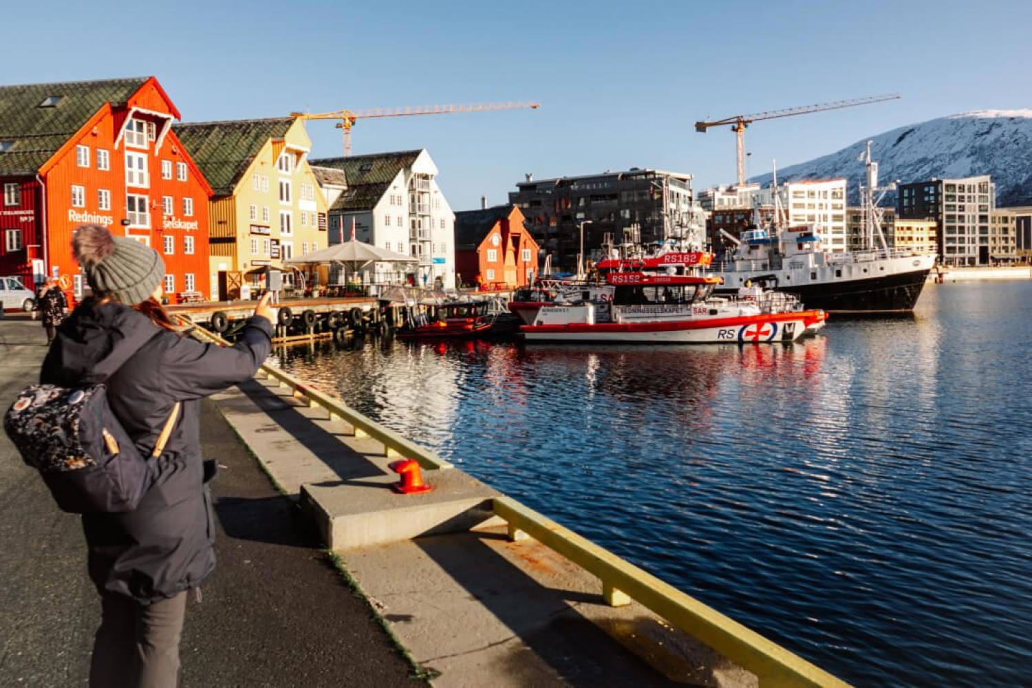Dame fotograferer fra brygga i Tromsø